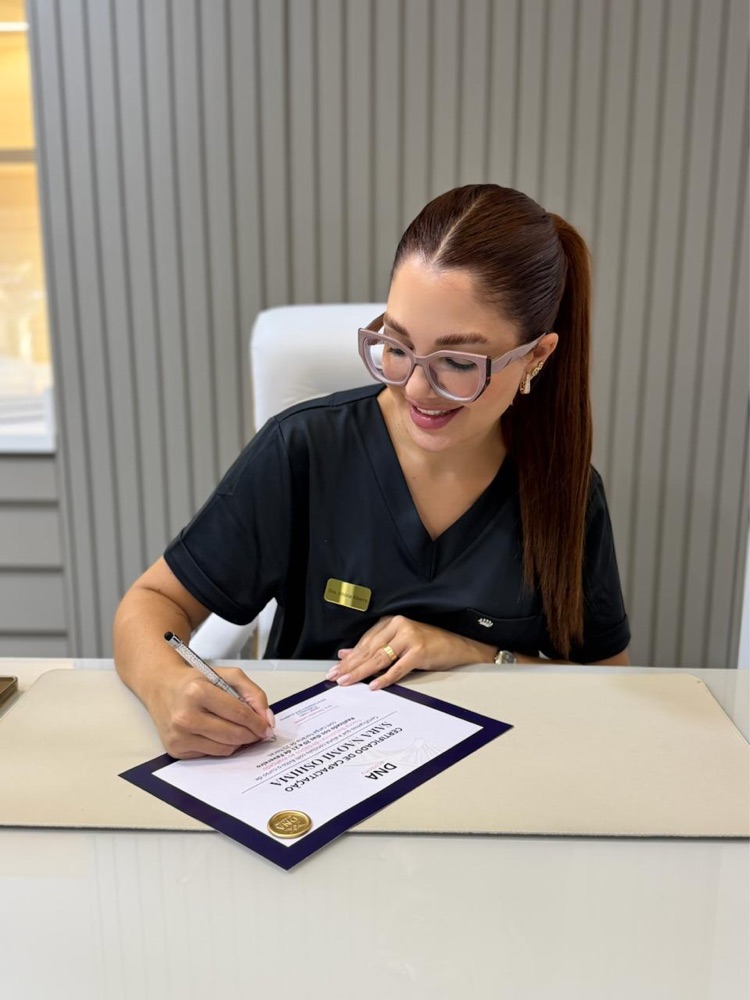 Dra. Vitória Ribeiro assinando um certificado de capacitação da DNA Academy